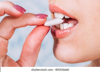 
She Puts In His Mouth Chewing Gum . Close-up Care Of The Teeth