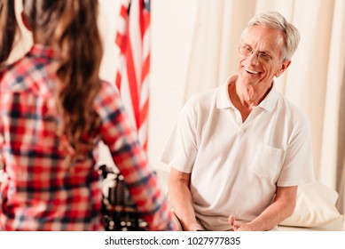 She is so smart. Selective focus on an extremely happy grandfather wearing glasses grinning broadly while looking at his grandchild and listening to her stories. - Powered by Shutterstock