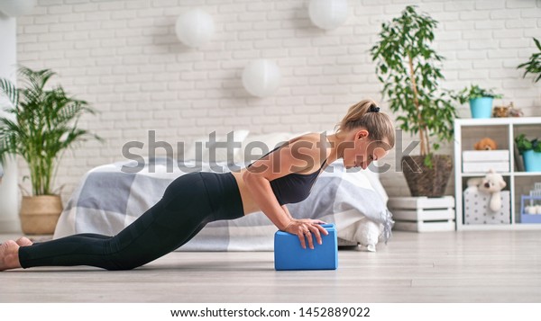 She stays in the Board and uses yoga blocks for\
her wrists. lying parallel to the floor, pushing the body up, knees\
bent. Urantia strap using yoga blocks. push-up on the floor on the\
blocks