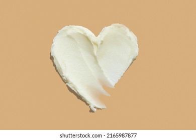 Shea butter cream textured heart shape smear on beige brown colour background, hair and skin care love swatch - Shutterstock ID 2165987877