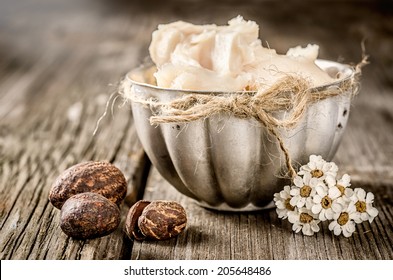 Shea butter and nuts on a wood