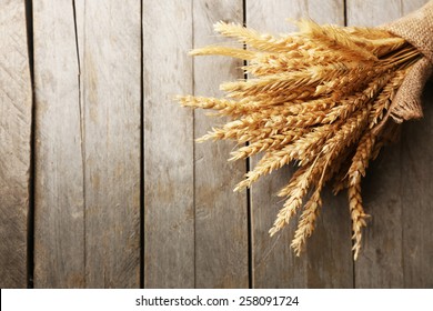 Sheaf Of Wheat On Wooden Background