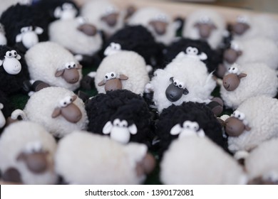 Sheep souvenir. A flock of sheep toy for souvenirs including black and white sheep. Soft focus.