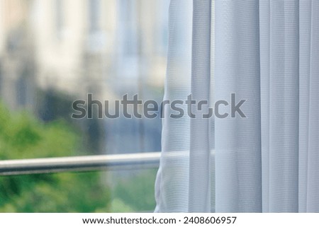 sheer curtain (translucent fabric) and balcony from high rise condominium, lonely feeling after staying home all day or all week, living alone in self-isolation, shallow depth of field
