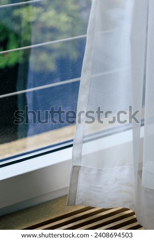 sheer curtain (translucent fabric) and balcony from high rise condominium, lonely feeling after staying home all day or all week, living alone in self-isolation, shallow depth of field