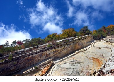 Sheer Rock Climb To Tree Line At Top Of Appalachian Mountainside.  Fall Leaves Color Trees And Blue Sky And Whispy Clouds Top Photo.