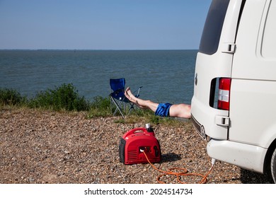 Sheerness UK - 06 22 2021: A Man Sun Bathing On A Solitary Beach Lying By Its Van.