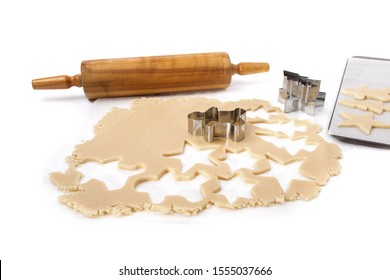 A Sheet Of Cookie Dough With Many Christmas Cookies Cut Out Of It Isolated On White