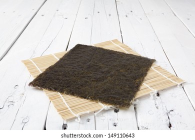 A Sheet Of Dried Seaweed Nori On A Makisu Mat On A White Aged Table With Copy Space