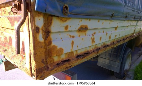 Sheet Metal Corrosion Of Old Truck Body. Rusty Surface, Background And Damaged Texture From Road Salt And Reagents. Protection Car And Professional Paint Work Concept. Messy Dirty Rust Cargo Bed. 