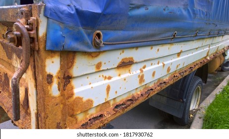 Sheet Metal Corrosion Of Old Truck Body. Rusty Messy Surface. Damaged Grunge Texture From Road Salt. Rust Background. Protection And Painting Auto In Winter. Paintwork. Car Bodywork.