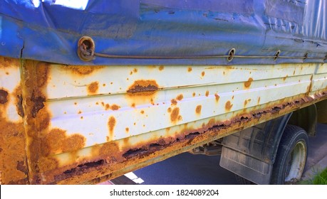 Sheet Metal Corrosion Of Old Truck Body. Rusty Messy Surface. Damaged Grunge Texture From Road Salt. Rust Background. Protection And Painting Auto In Winter. Paintwork. Car Bodywork. Lorry. Service.