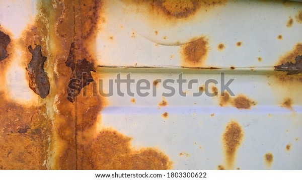 Sheet metal corrosion of old white car. Rusty messy\
surface. Damaged grunge texture from road salt. Rust background.\
Protecting automobile concept. Copy space. Professional service.\
Paint work.