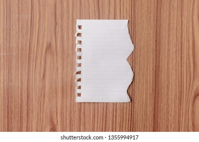 Sheet Of Notebook Paper With Torn Edge Blank Ripped Piece On Isolated Over Wooden Table Background. Empty Damaged Rip Paper Shape. Clipping Path, Copy Space Room For Text, Educational Design Concept