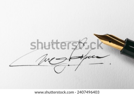 Sheet of paper with fountain pen and signature, top view