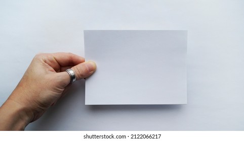 A sheet of paper in the hands of a man on a white background - Shutterstock ID 2122066217