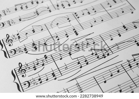 Sheet of paper with music notes as background, closeup view