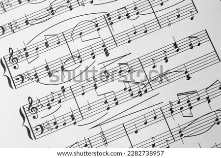 Sheet of paper with music notes as background, closeup view