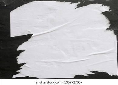 A sheet of white paper glued on a black wall. - Shutterstock ID 1369727057