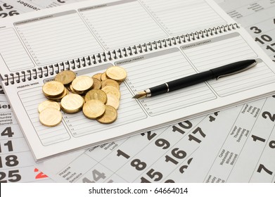 Sheets of a calendar with coins and a notebook