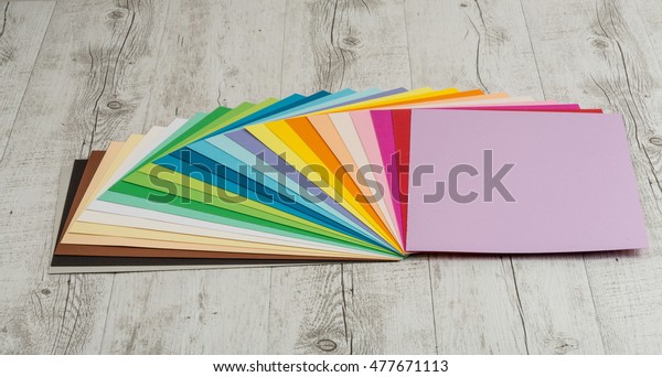 Sheets of colored paper,\
iridescent palette of colored paper, rainbow colors, rainbow\
colors, watercolors, wax crayons, colored markers, crayons on the\
wooden table