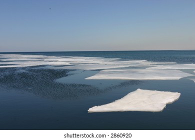 Sheets Of Ice Flow Against A Blue Sky