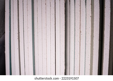 A Lot Of Sheets Of Moisture-resistant Drywall Close-up At A Construction Site. Universal Facing Material. Folded Building Materials After Delivery. Texture Of Gypsum Filler