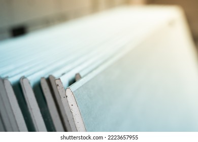 A Lot Of Sheets Of Moisture-resistant Drywall Close-up At A Construction Site. Universal Facing Material. Folded Building Materials After Delivery