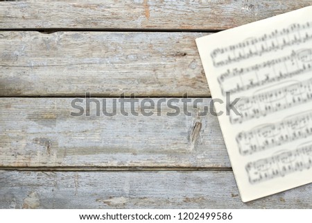 Sheets with musical notes and copy space. Musical papers on old wooden background. Classic music concept.