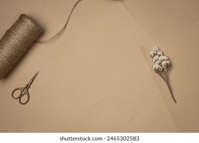 Sheets of paper background with string, scissors and flower. Vintage. Flat lay, top view. Copy space