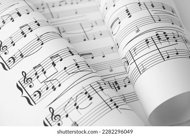 Sheets of paper with music notes as background, closeup view