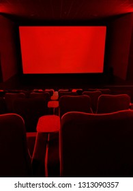 SHEFFIELD, UK - FEBRUARY 14, 2019: Blank screen and rows of generously proportioned, large modern seats in a screen room at The Light cinema, with striking red lighting