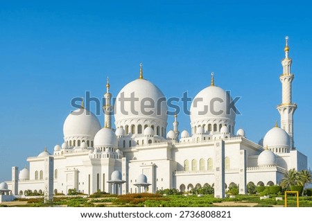 Sheikh Zayed Grand Mosque with multiple domes and minarets under clear blue sky in Abu Dhabi, United Arab Emirates. Islamic architectural heritage. Travel and tourism in UAE