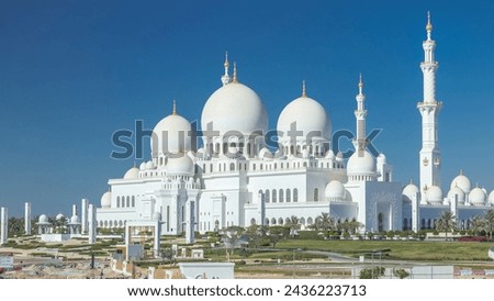 Sheikh Zayed Grand Mosque timelapse in Abu Dhabi, the capital city of United Arab Emirates. Back side with trees and traffic on the road from above. Blue sky at sunny day