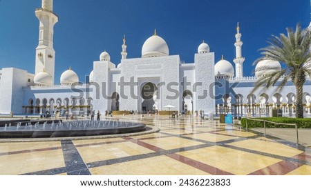 Sheikh Zayed Grand Mosque timelapse hyperlapse in Abu Dhabi, the capital city of United Arab Emirates. Front view with fountains. Blue sky at sunny day