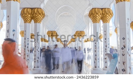 Sheikh Zayed Grand Mosque timelapse in Abu Dhabi, the capital city of United Arab Emirates. People walking between columns. Blue sky at sunny day