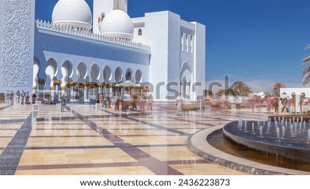 Sheikh Zayed Grand Mosque timelapse in Abu Dhabi, the capital city of United Arab Emirates. Front view with fountains. Blue sky at sunny day