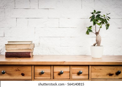 Shelf With A Book And Flower And A White Brick Wall