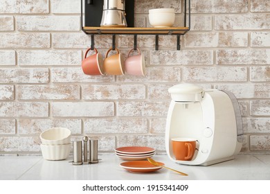 Shelf With Cups And Coffee Machine On Table In Kitchen