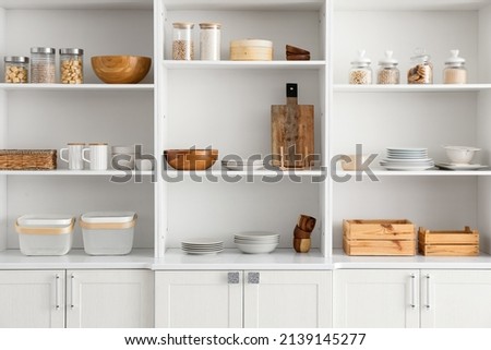 Shelf unit with clean dishware in kitchen