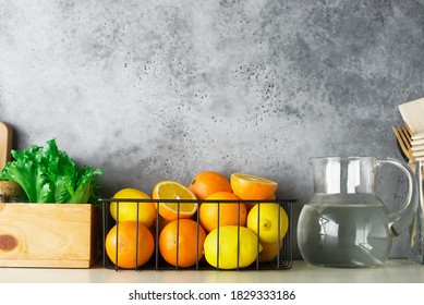 Shelf In A White Kitchen With Fresh Fruits, Herbs, Cutlery, Kitchen Utensils, Tools, Textiles, Fresh Water In A Decanter. Home, Family, Simplicity