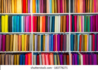 Shelf With A Wide Selection Of Colorful Fabrics.