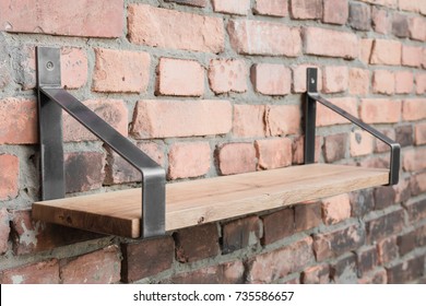 Shelf In Wood And Metal Hanging On A Brick Wall In Loft Style.