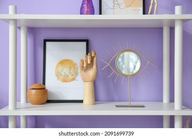 Shelf With Wooden Hand, Picture And Mirror Near Color Wall