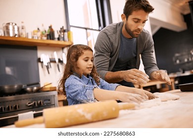 Shell be an expert masterchef one day. a little girl and her dad working with pizza dough in the kitchen. - Powered by Shutterstock