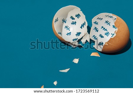 The shell of a broken egg lies on a blue table. Inside the shell, the days of release from captivity were counted. Tally chart.