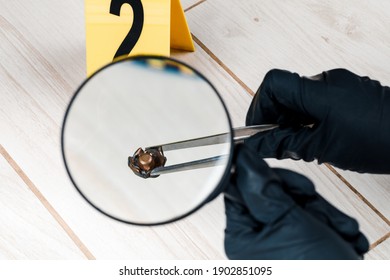 A shell casing or bullet at a crime scene with evidence markers