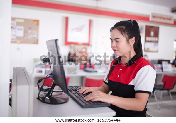 Shell sells serious Asian people using a\
laptop, watching computers, talking on the phone, consulting\
customers in a motorcycle\
showroom.
