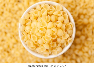 Shell shaped pasta in bowl. Uncooked, dry conchiglie macaroni - Powered by Shutterstock