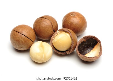 Shelled and unshelled macadamia nuts on white background